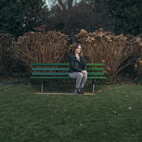 Einsame Frau sitzt allein im Park.