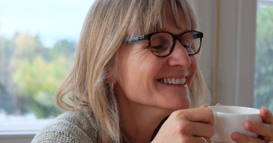 Irene Widmer-Huber in der Stube des Moosrain in Riehen trinkt aus einer weissen Tasse.