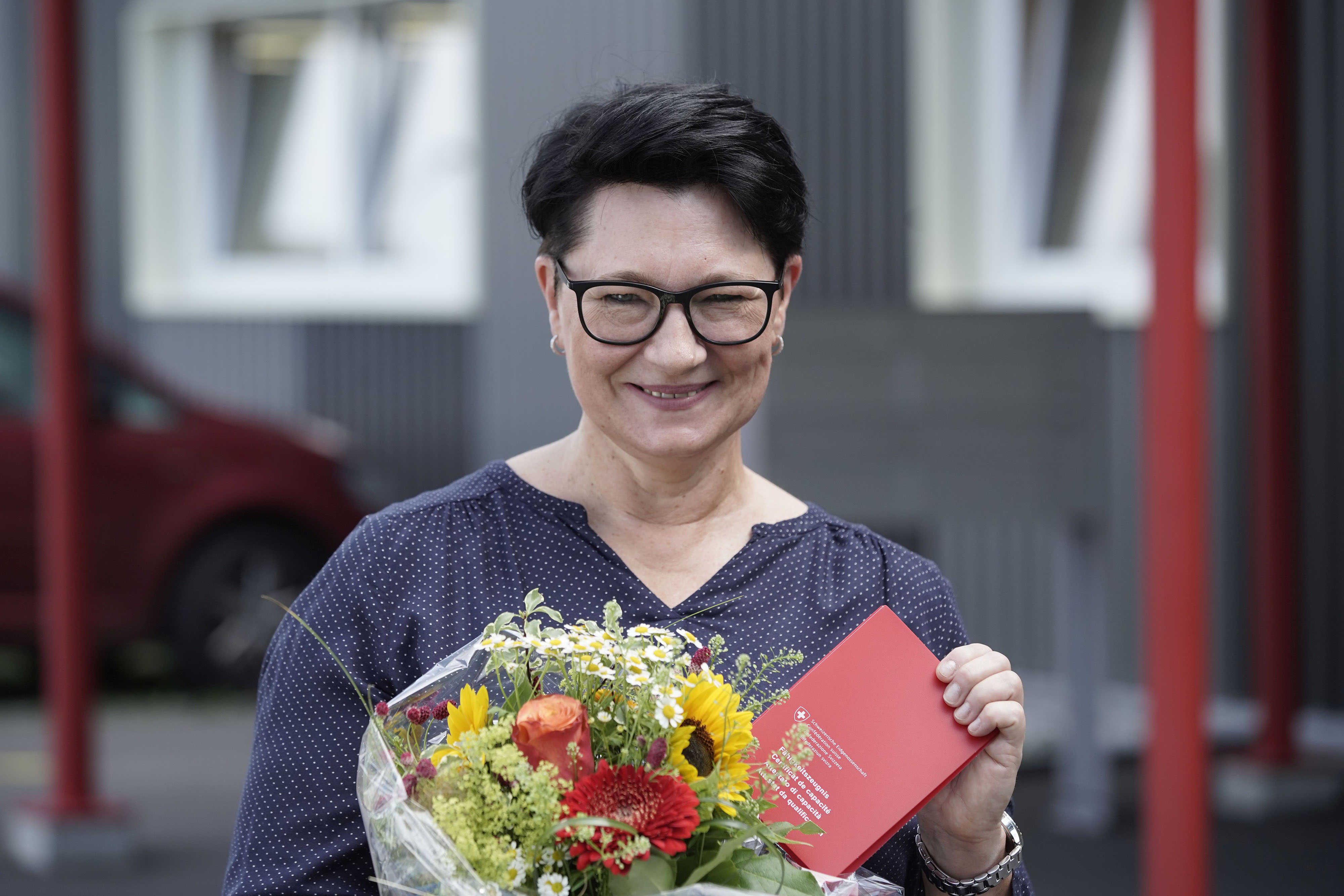 Frau Anke mit Fähigkeitszeugnis und Blumenstrauss