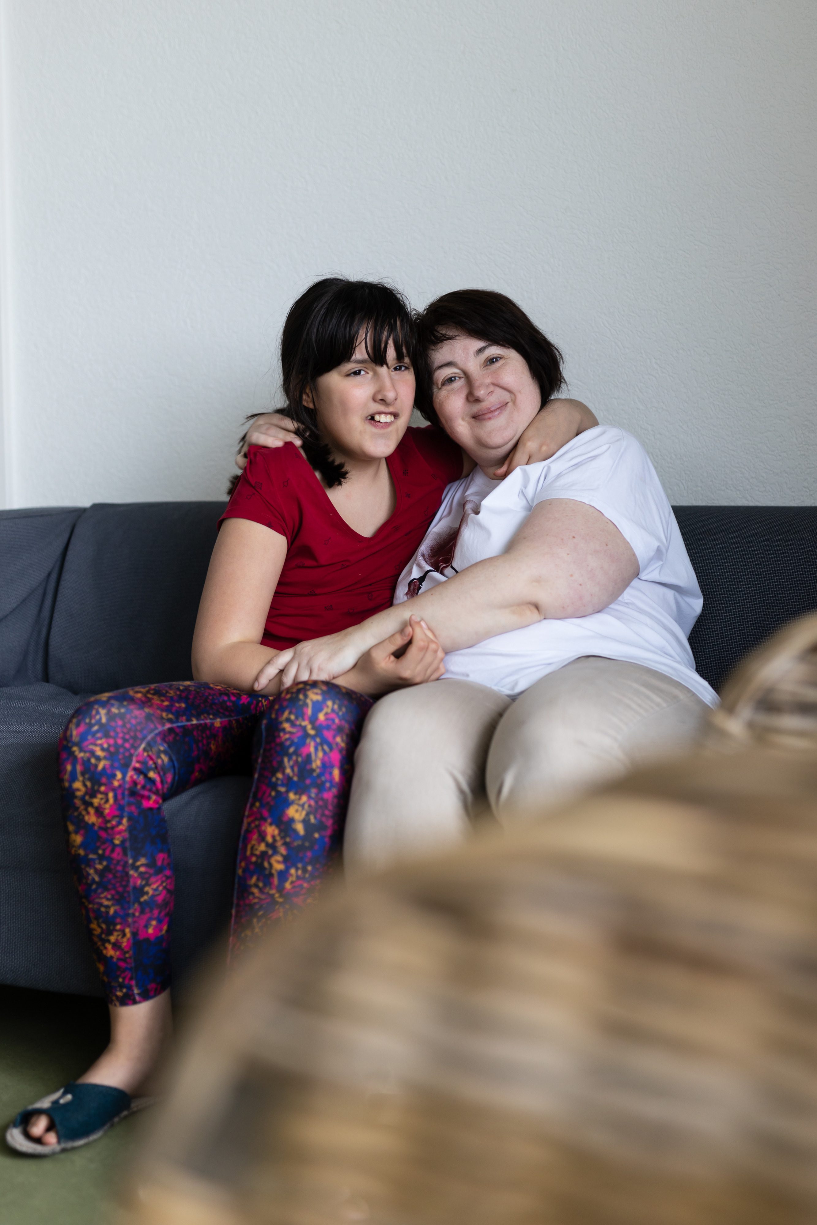 Ukraine Flüchtlinge_Mutter und Tochter umarmen Sofa