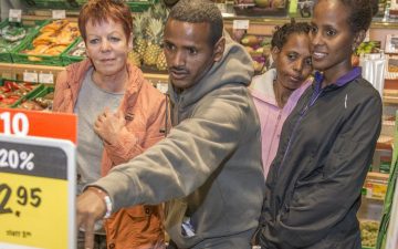 Eine Freiwillige der Flüchtlingshilfe der Heilsarmee bietet geflüchteten Menschen Unterstützung und Orientierung in alltäglichen Situation in der Schweiz, wie hier beispielsweise beim Einkaufen in einem Lebensmittelgeschäft.