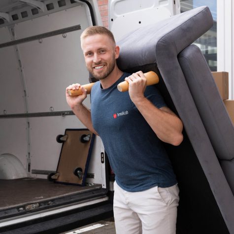 Die Brocki holt auch schwere Möbel ab Brocki Räumung - Sofa wird in Lieferwagen getragen.