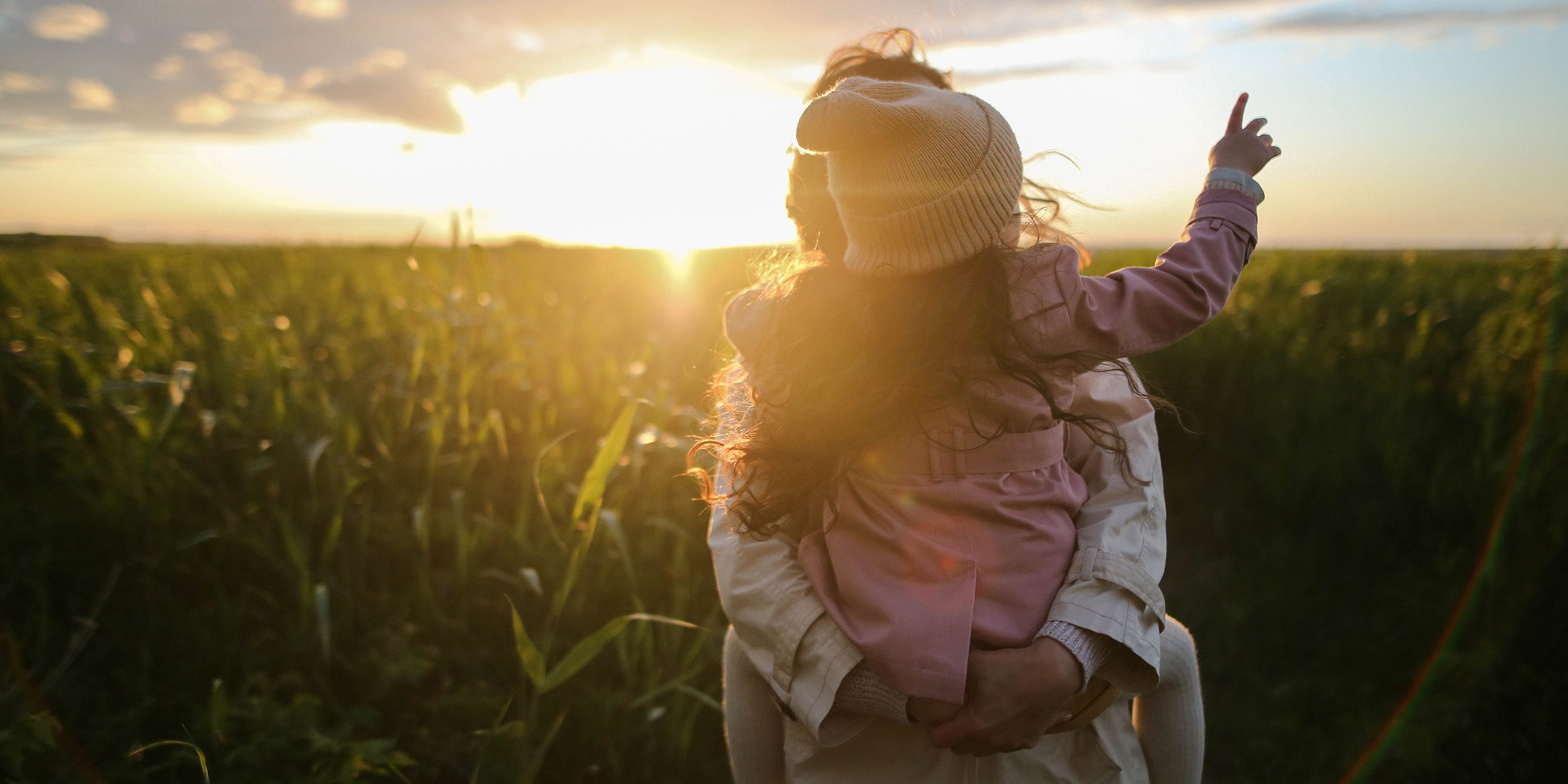 Symbolbild einer Frau mit Kind in einem Feld.