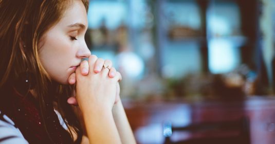 Frau betet mit geschlossenen Augen. Bild: Pexels