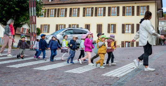 Les enfants traversent le village de Saint-Aubin avec deux assistantes maternelles.