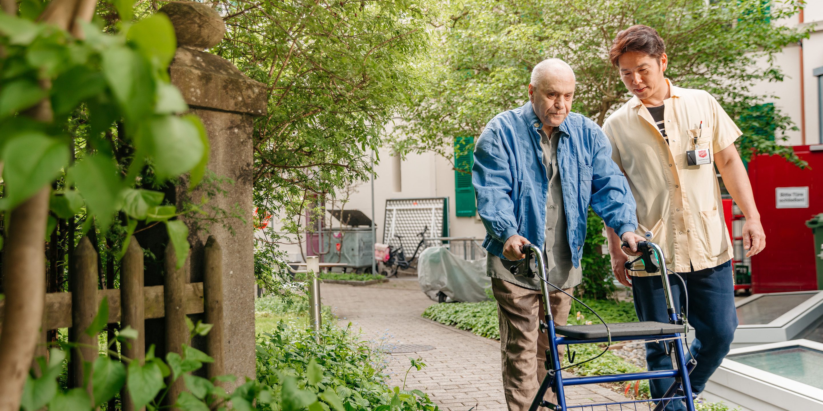 Symbolbild Altersheime Pflegender mit Senior am Rollator.