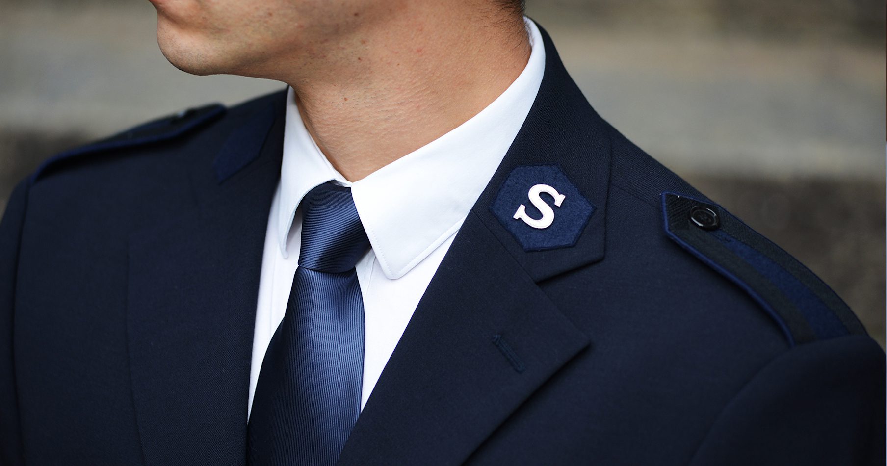 Heilsarmee Uniform mit dem „S“ auf dem Kragen.