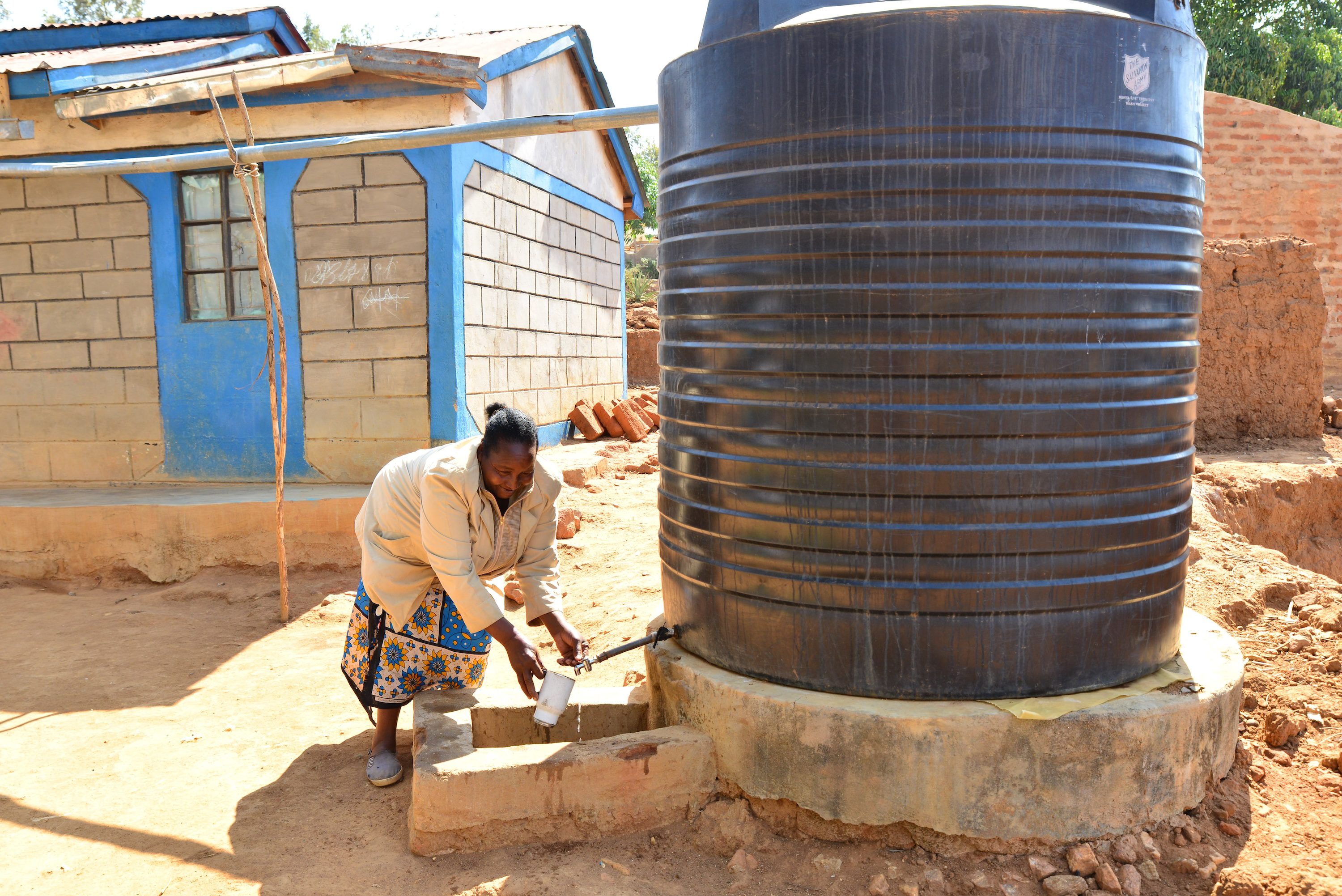 WASH Kenia Tabitha nimmt Wasser aus ihrem Tank