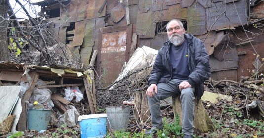 Yuri, ein Ukrainer, sitzt vor den Trümmern seines Hauses. Die Heilsarmee Ukraine konnte ihm helfen.